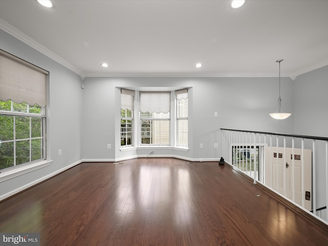 spare room featuring crown molding, recessed lighting, wood finished floors, and baseboards