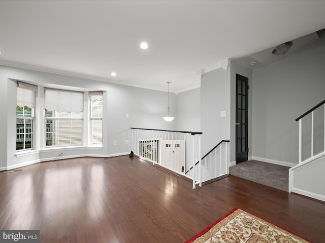 unfurnished living room with wood finished floors, baseboards, recessed lighting, and crown molding