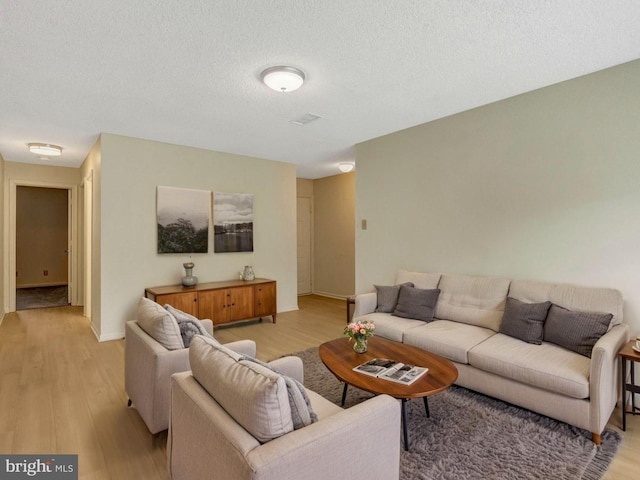 12106 Green Leaf Ct Unit 102, Fairfax, VA 22033 - living area featuring light wood-type flooring, baseboards, and a textured ceiling