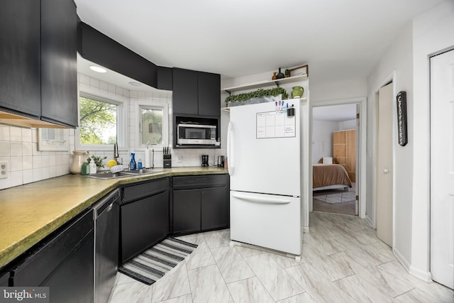 26882 Pratt Rd, Salisbury, MD 21801 - kitchen with stainless steel appliances, dark cabinetry, tasteful backsplash, a sink, and light marble finish flooring
