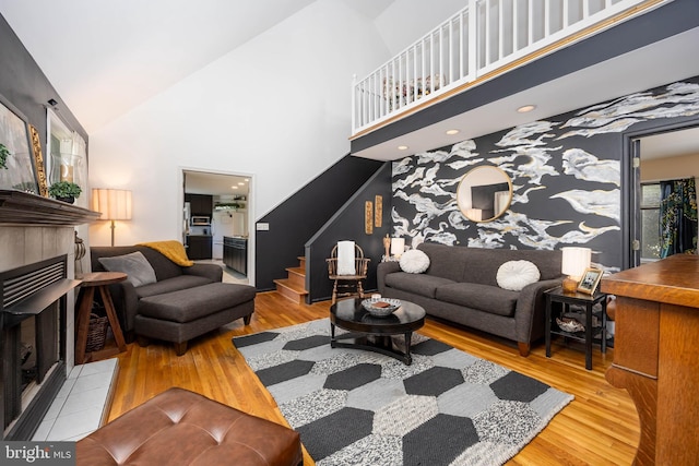 26882 Pratt Rd, Salisbury, MD 21801 - living area with a tile fireplace, stairs, a high ceiling, and wood finished floors