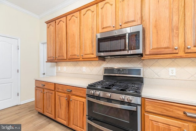 111 Central Parke E, Ocean Pines, MD 21811 - kitchen featuring stainless steel appliances, backsplash, ornamental molding, light countertops, and light wood-style floors