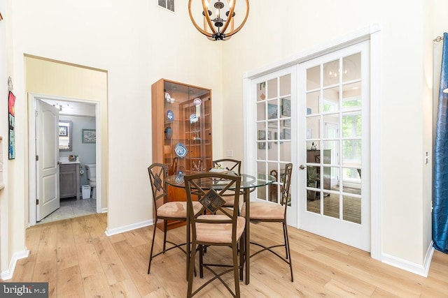 111 Central Parke E, Ocean Pines, MD 21811 - dining area with light wood-style floors, a chandelier, baseboards, french doors, and a towering ceiling