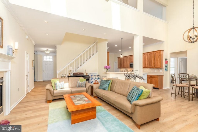 111 Central Parke E, Ocean Pines, MD 21811 - living area featuring stairs, light wood-style floors, a glass covered fireplace, a chandelier, and a towering ceiling
