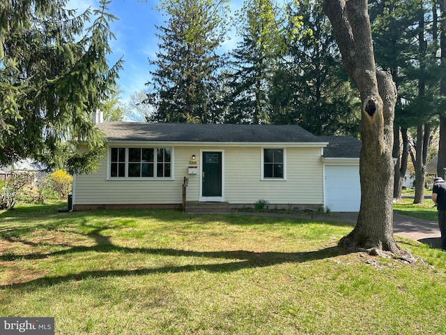 ranch-style home with a front yard, an attached garage, and entry steps