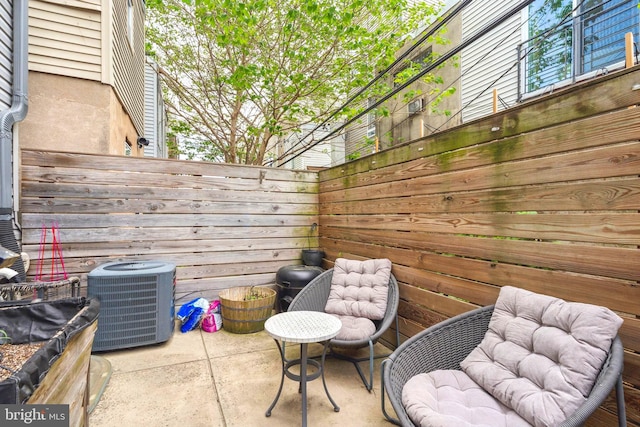 view of patio / terrace with central AC unit and fence