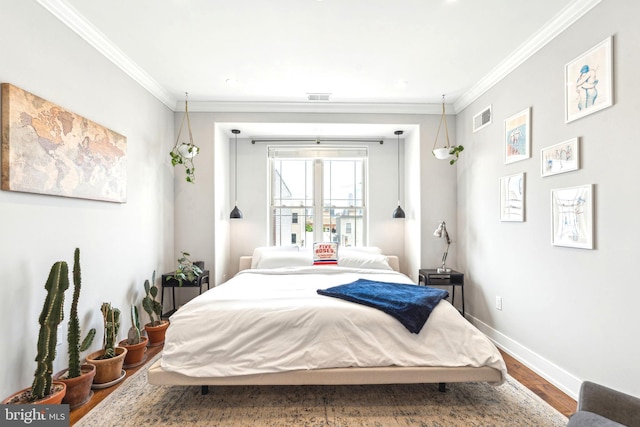bedroom with wood finished floors, baseboards, and ornamental molding