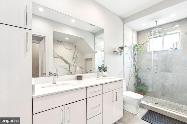 bathroom with a marble finish shower, toilet, double vanity, and recessed lighting