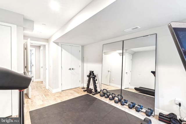 exercise room featuring light wood-style floors and baseboards