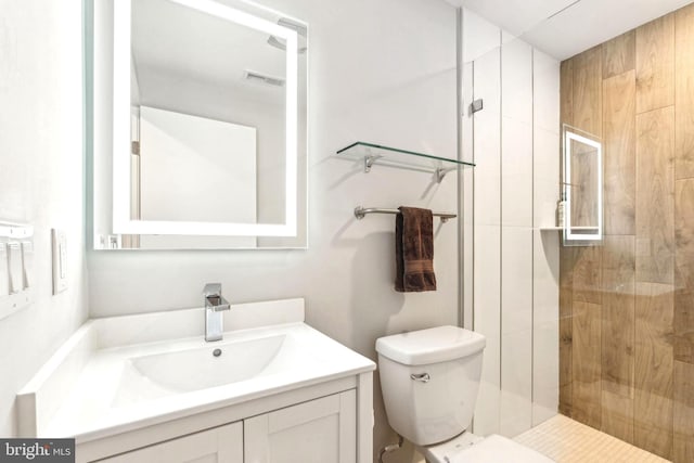 bathroom featuring a stall shower, vanity, and toilet