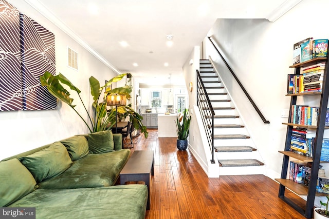 living room with stairs, hardwood / wood-style floors, baseboards, crown molding, and recessed lighting