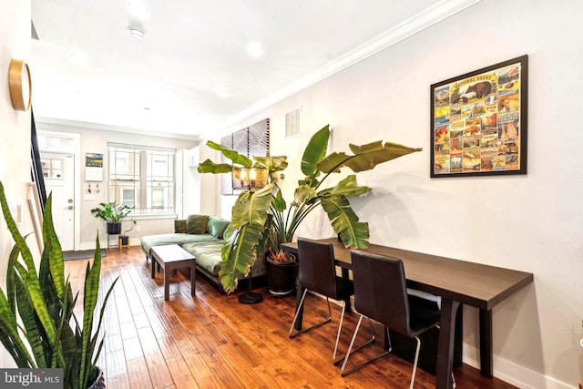living area featuring ornamental molding, wood-type flooring, and baseboards