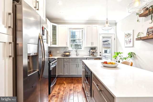 kitchen with stainless steel appliances, light countertops, a sink, dark wood-style floors, and gray cabinets