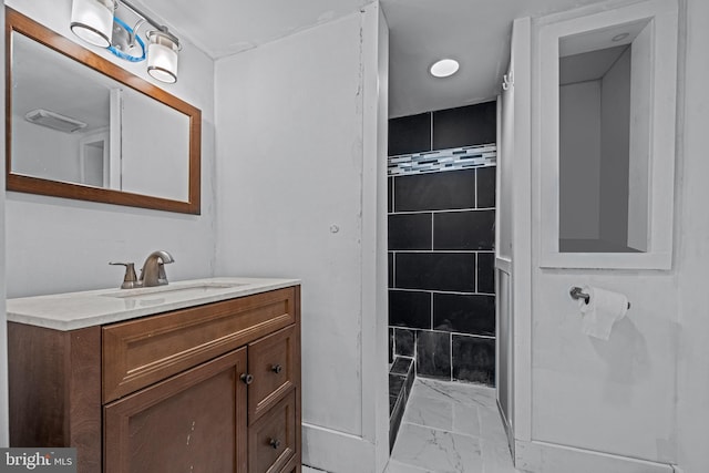 bathroom with marble finish floors and vanity