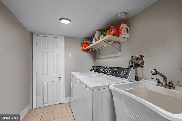 laundry room with washer and dryer, baseboards, and light tile patterned floors