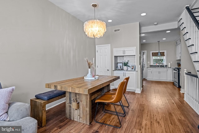 dining area featuring a chandelier, hardwood / wood-style flooring, and recessed lighting