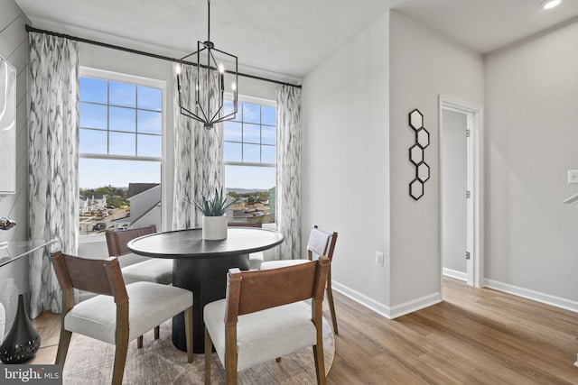 dining room with a chandelier, wood finished floors, and baseboards