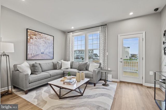 living room featuring light wood-style floors, baseboards, and recessed lighting
