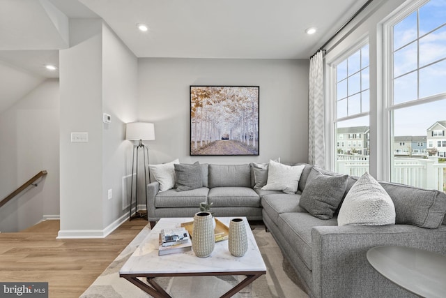 living area with light wood-type flooring, baseboards, and recessed lighting