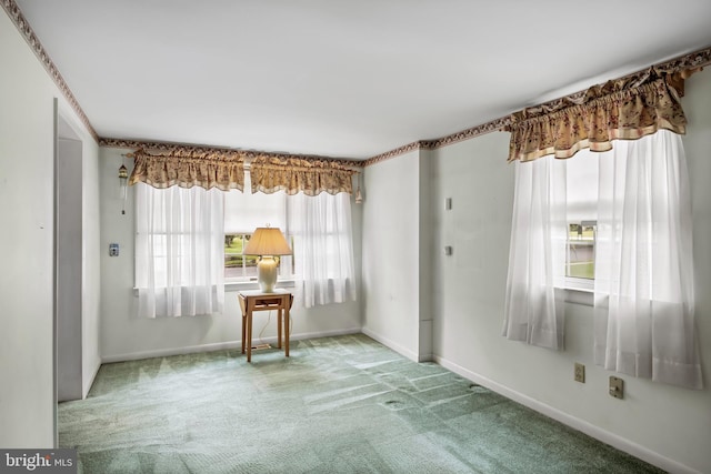 carpeted empty room with healthy amount of natural light and baseboards