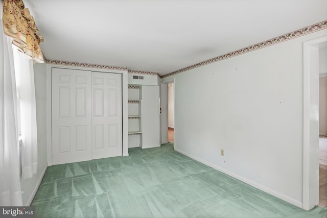 unfurnished bedroom with light colored carpet, a closet, and baseboards