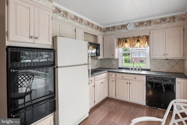 kitchen with black appliances, a sink, a warming drawer, and dark countertops