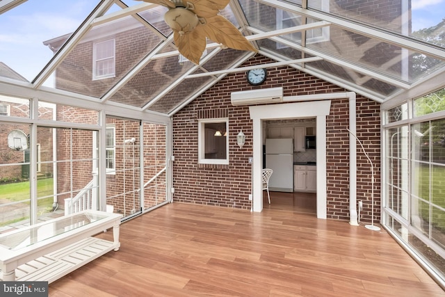 unfurnished sunroom with a wall mounted air conditioner, lofted ceiling, and ceiling fan