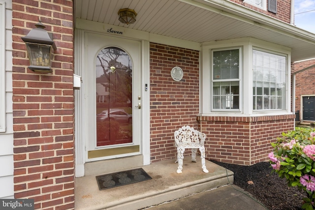 doorway to property with brick siding