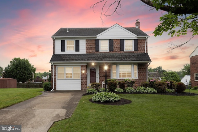 traditional-style home with brick siding, a chimney, driveway, and roof with shingles