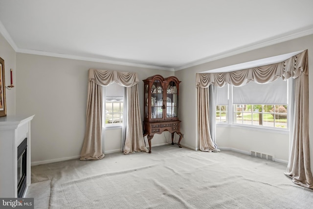 unfurnished living room featuring crown molding, carpet, a fireplace, and baseboards