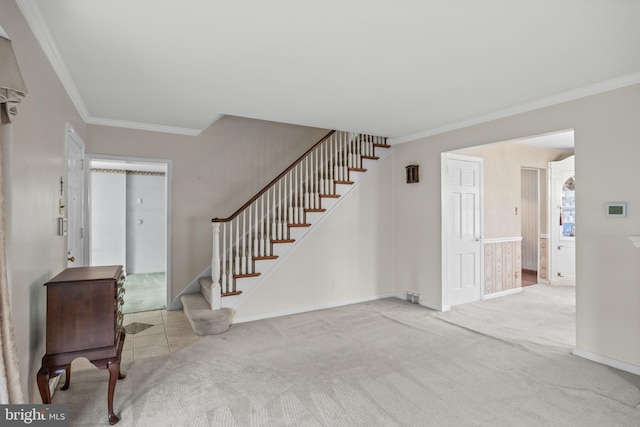 carpeted foyer entrance with crown molding, stairway, and baseboards