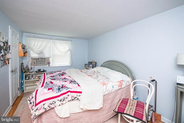 bedroom with cooling unit and wood finished floors