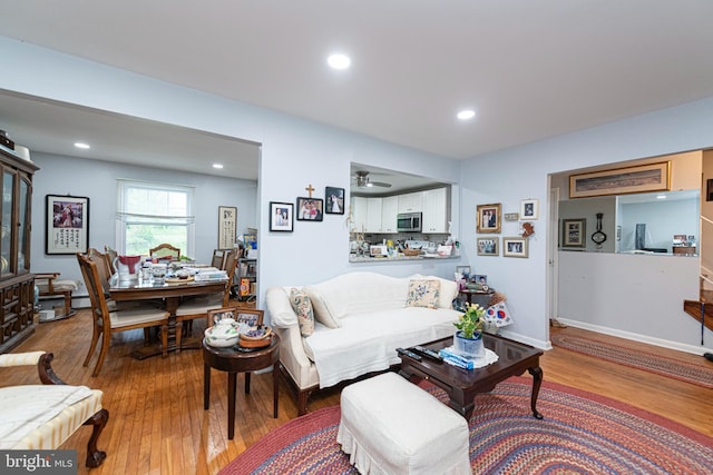 living area with wood-type flooring, recessed lighting, and ceiling fan