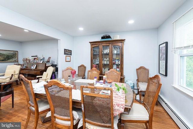 dining room featuring baseboard heating, light wood-type flooring, and recessed lighting