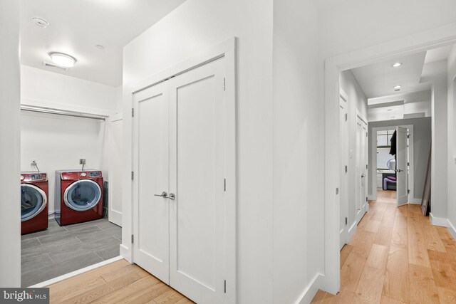 corridor with light wood finished floors, washer and dryer, recessed lighting, and baseboards