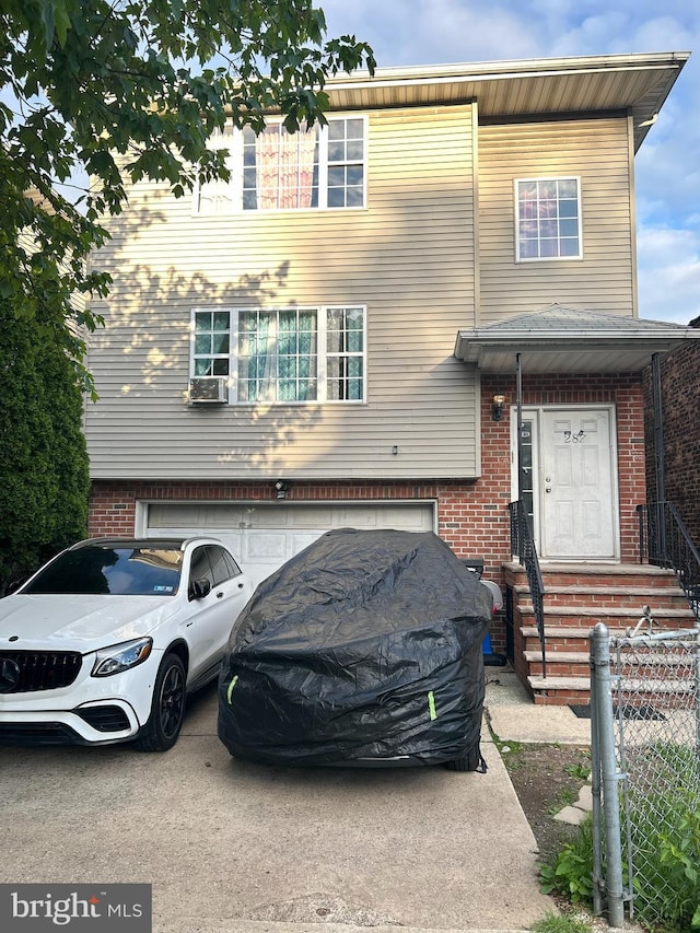 view of front of home with a garage, brick siding, fence, and cooling unit