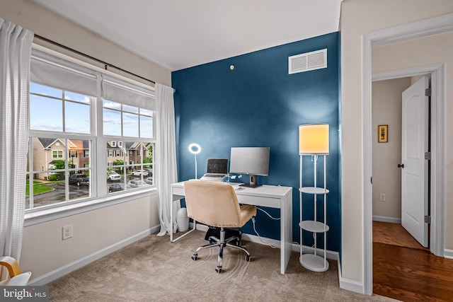 carpeted office space featuring baseboards