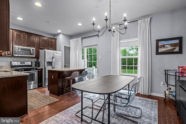 dining room featuring dark wood-style flooring, recessed lighting, a chandelier, and baseboards