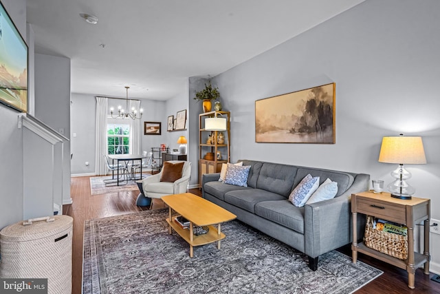 living room with a chandelier, wood finished floors, and baseboards