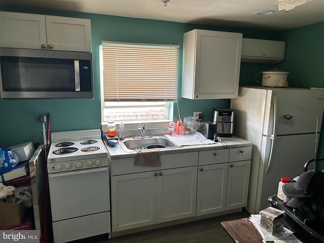 402 Market St, Marcus Hook, PA 19061 - kitchen with white appliances, a sink, a wall mounted AC, white cabinets, and wood finished floors