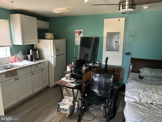 402 Market St, Marcus Hook, PA 19061 - kitchen featuring freestanding refrigerator, wood finished floors, a wall unit AC, white cabinets, and light countertops