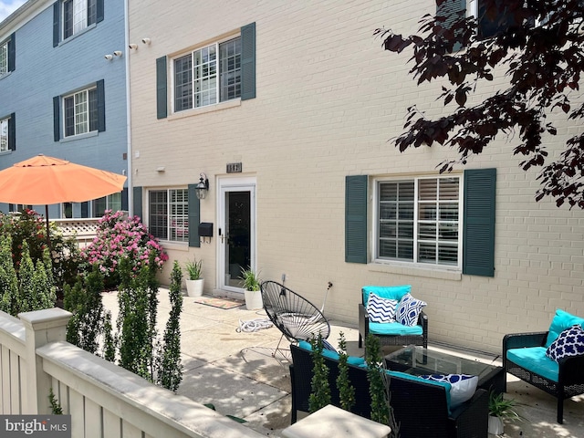 rear view of property featuring brick siding and a patio area