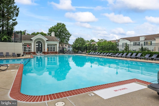 community pool featuring fence and a patio area