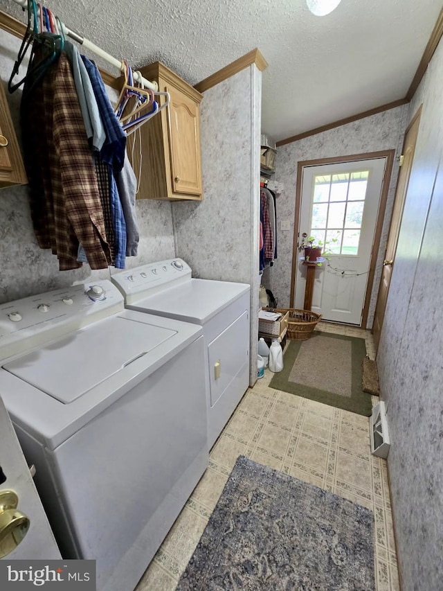 washroom with cabinet space, washing machine and dryer, ornamental molding, light flooring, and wallpapered walls