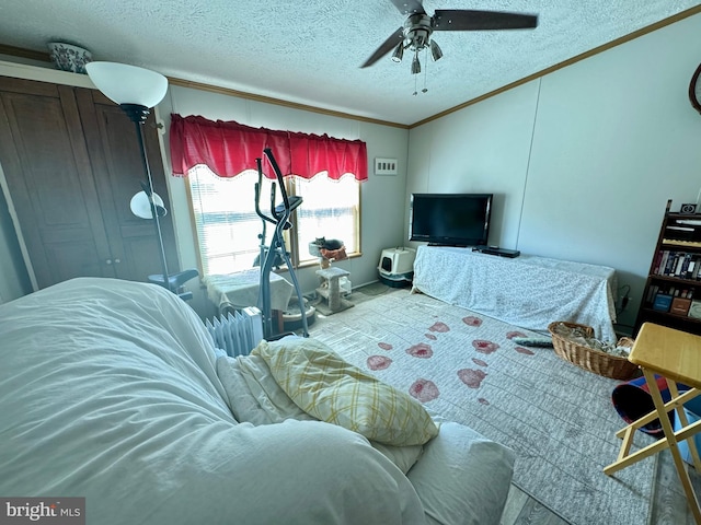 living room with ornamental molding, ceiling fan, a textured ceiling, and carpet flooring