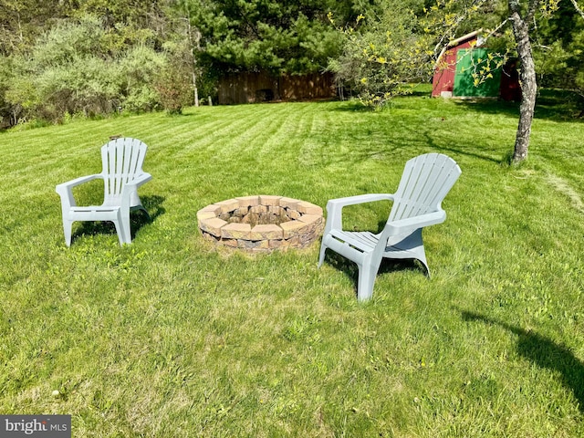 view of grassy yard featuring an outdoor fire pit