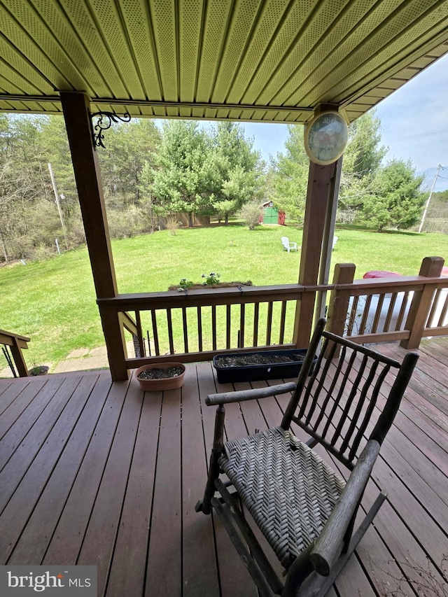 wooden deck featuring a lawn