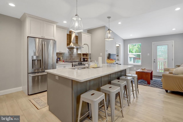 2914 6th St S, Arlington, VA 22204 - kitchen with stainless steel fridge, wall chimney range hood, white cabinetry, backsplash, and light wood-style flooring