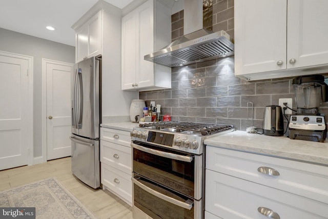 2914 6th St S, Arlington, VA 22204 - kitchen with stainless steel appliances, wall chimney exhaust hood, white cabinetry, light stone countertops, and backsplash