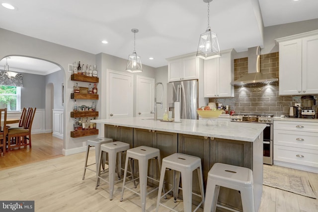 2914 6th St S, Arlington, VA 22204 - kitchen featuring stainless steel appliances, wall chimney range hood, white cabinetry, tasteful backsplash, and arched walkways